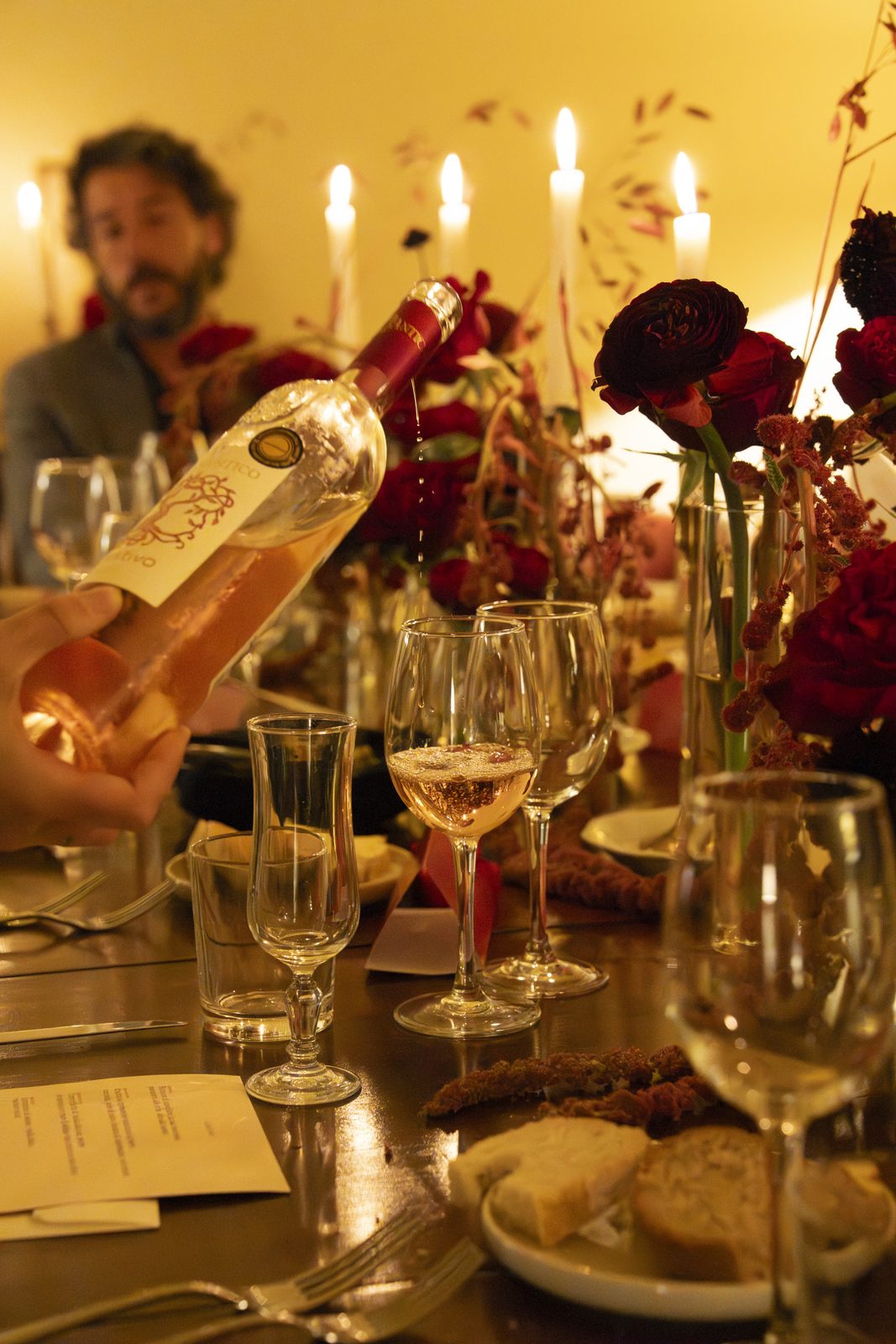 Servizio vino durante una cena privata Syntonia con candele e fiori